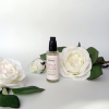 Imagen de un envase entre rosas blancas de Contorno de Ojos y Labios con algas marinas y extracto de hoja de olivo de Arboleda Cosmética Natural.